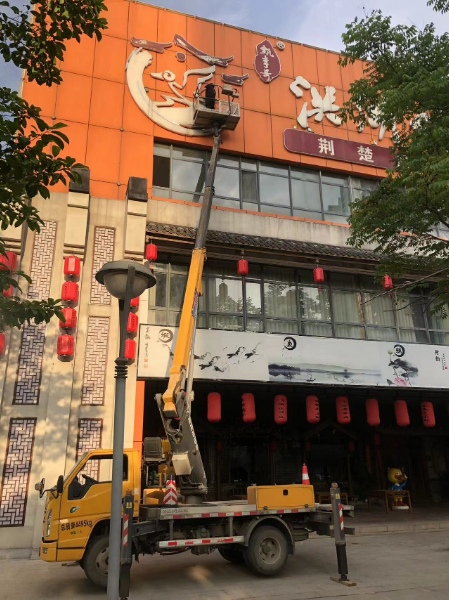 22米升降车安装饭店门头广告牌施工现场